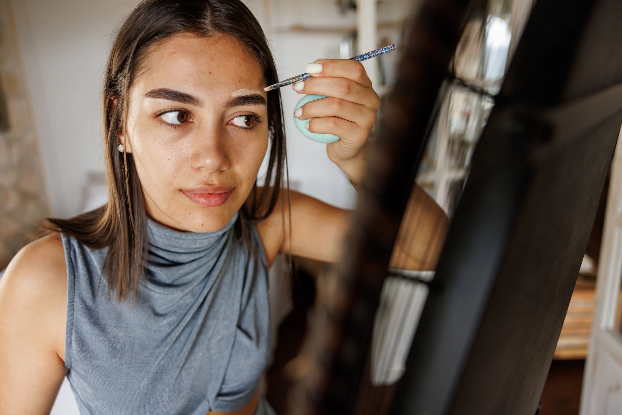 Woman getting ready in a mirror with a clean, natural makeup look