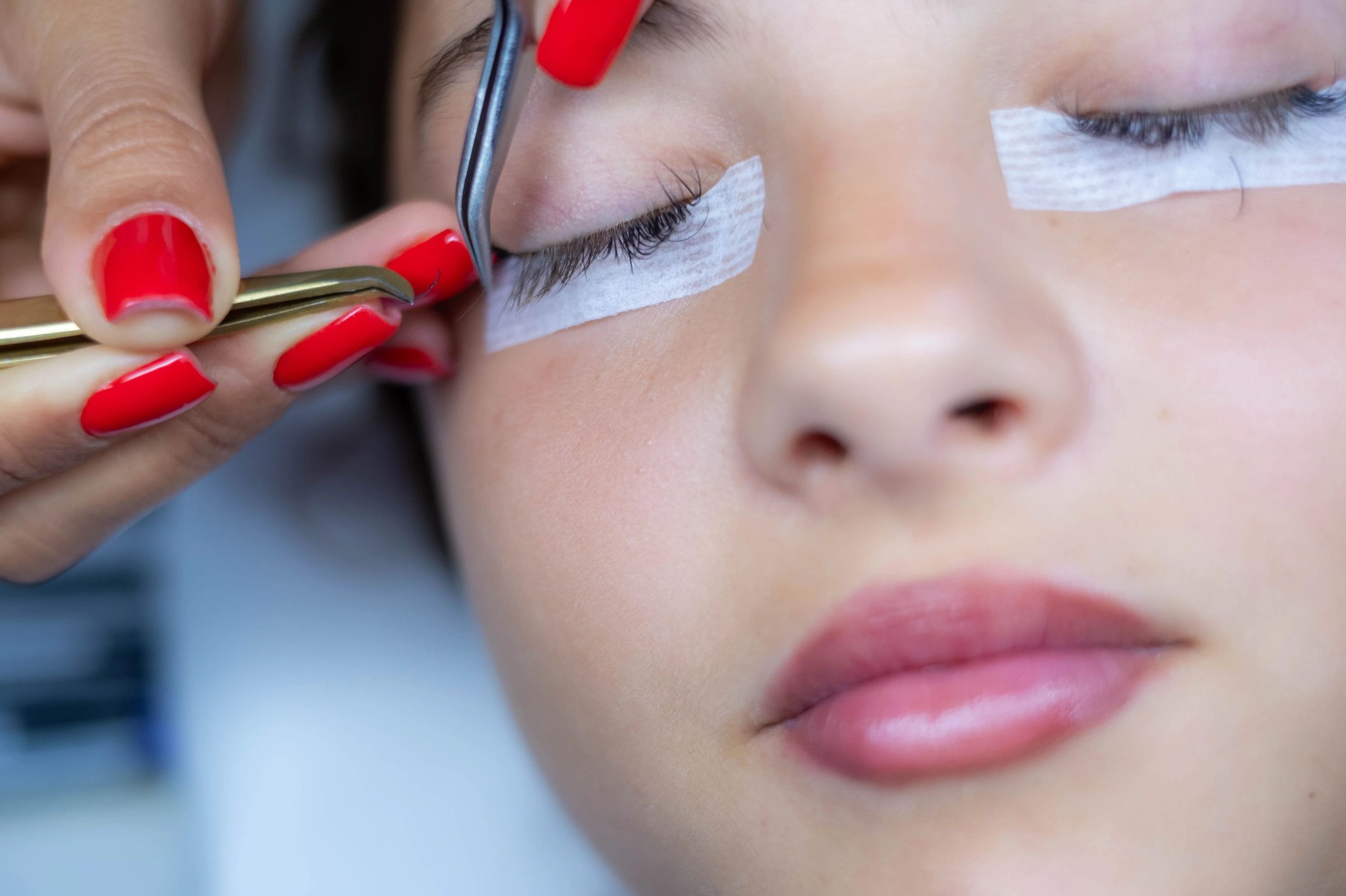 Aesthetician applying eyelash extensions to client