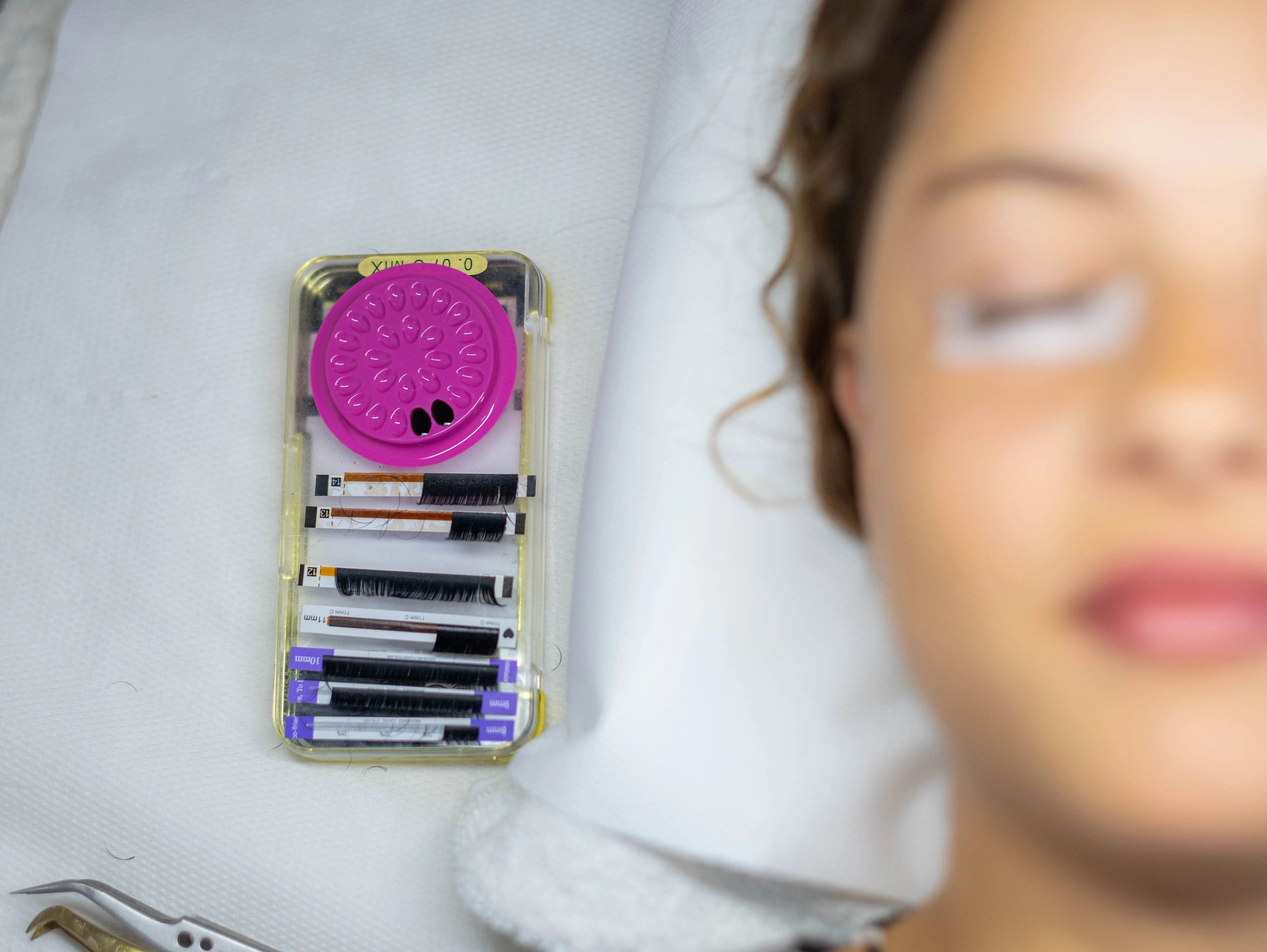 Woman receiving eyelash extensions in a luxury beauty studio